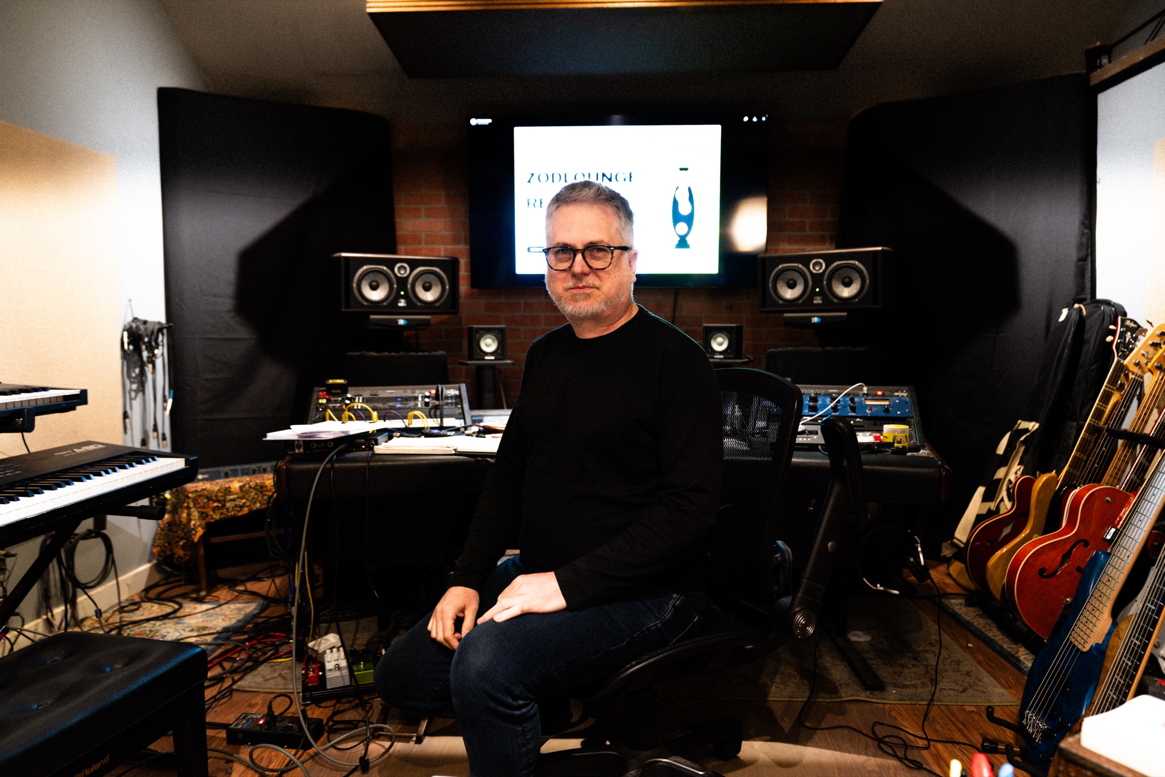 Wide shot of the Zodlounge studio. Console, monitors, and instruments.